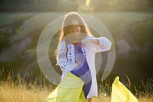 A beautiful teenage girl dressed in national clothes with the Ukrainian flag