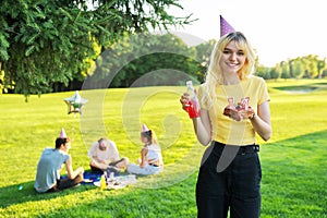 Beautiful teenage girl in a festiv hat on her birthday with a cake and candles. photo