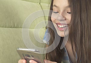 Beautiful teenage girl having fun communicating on smartphone