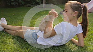 Beautiful teenage girl lying on grass with red cat on her belly