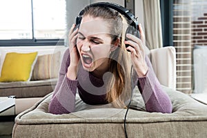 Beautiful teenage girl in pain screaming suffering from loud music