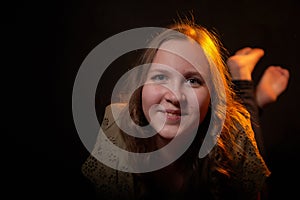 Beautiful teenage girl portrait on black background. Cute female odel posing in dark studio