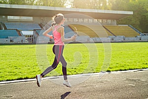 Beautiful teenage girl running in stadium