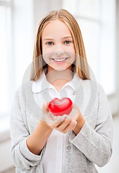 Beautiful teenage girl showing red heart