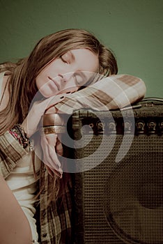 A beautiful teenage girl sleeping on a sound device