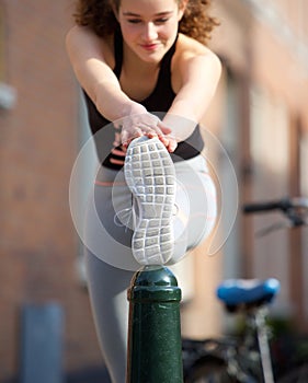 Beautiful teenage girl stretching leg muscle