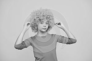 Beautiful teenage girl in wig isolated on yellow. Funny clown wig.