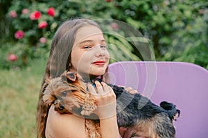 Beautiful teenage girl with a Yorkshire terrier dog in her hands