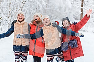 Beautiful teenage girls having fun outside in a wood with snow in winter. Friendship and active life consept