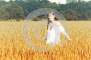 Beautiful Teenage Model girl Dressed in Casual Short Dress on the Field in Sun Light.