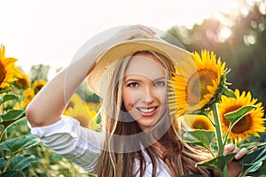 Beautiful Teenage Model girl with long healthy hair posing on the Sunflower Spring Field