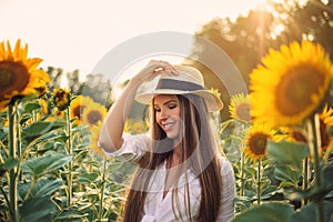 Beautiful Teenage Model girl with long healthy hair posing on the Sunflower Spring Field