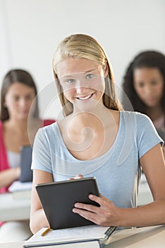 Beautiful Teenage Student Holding Digital Tablet At Desk