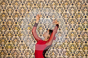 Beautiful teenage woman dancing flamenco doing different flamenco dance postures on a background of typical arabic tiles. She