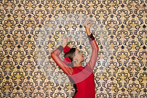 Beautiful teenage woman dancing flamenco doing different flamenco dance postures on a background of typical arabic tiles. She