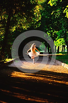 Beautiful teenager girl Is dancing outside at summer sunset