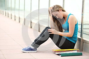 Beautiful teenager girl depressed sitting on the floor outdoor photo