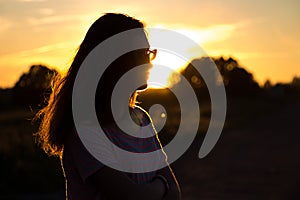 Beautiful teenager girl with glasses in sunset