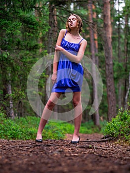 Beautiful teenager girl in high fashion dress posing in a forest park. Prom or special event. Young lady in classic outfit. Model