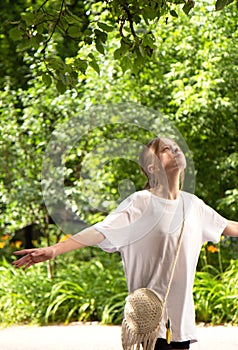 Beautiful teenager girl walks in the park. Walk in nature in summer