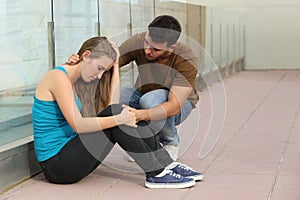 Beautiful teenager girl worried and a boy comforting her photo