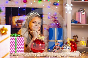 Beautiful ten-year-old girl lies on a rug in the New Yearâ€™s interior and looks at the frame cheerfully