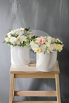 Beautiful tender bouquet of flowers in white box on gray ackground with space for text