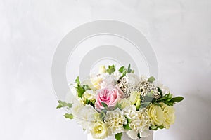 Beautiful tender bouquet of flowers in white box on light ackground with space for text