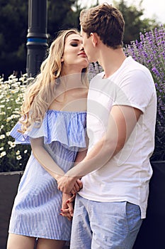 Beautiful tender couple in casual clothes posing in garden