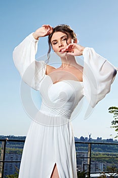 Beautiful tender young woman sexy brunette bride in a luxury white wedding dress lace chiffon Summer happiness awaits the groom