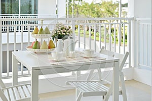 Beautiful terrace with white furniture and tea or coffee set