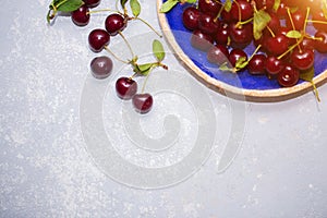 Beautiful texture, background with ripe cherries in a plate, top view