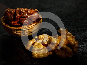 Beautiful textured Half split walnut in shell and walnut kernel on black background
