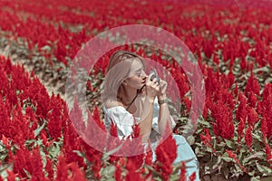 Beautiful Thai lady is walking around and taking photos in a beautiful flower garden.