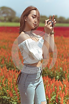 Beautiful Thai lady is walking around and taking photos in a beautiful flower garden.