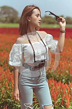 Beautiful Thai lady is walking around and taking photos in a beautiful flower garden.