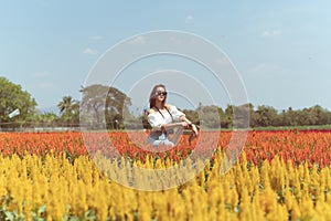 Beautiful Thai lady is walking around and taking photos in a beautiful flower garden.