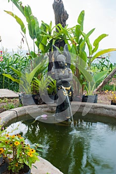 A beautiful Thai-style fairy statue standing in a pool of home g