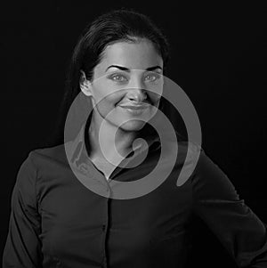 Beautiful thinking toothy smiling business woman looking in blue shirt on black background with empty copy space for text. Closeup