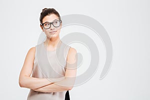 Beautiful thoughtful young business woman standing with arms crossed