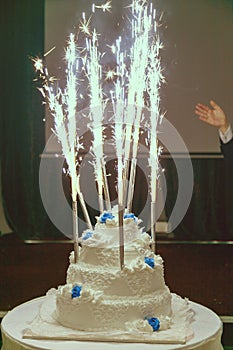 Beautiful three-layered wedding cake with fireworks