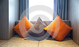 Beautiful three pillows on sofa interior decoration in living room with curtains and window
