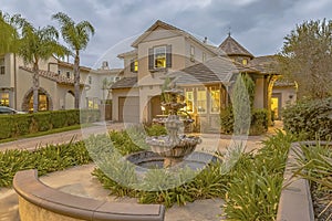 Beautiful tiered fountain at the garden of a home against sky with gray clouds