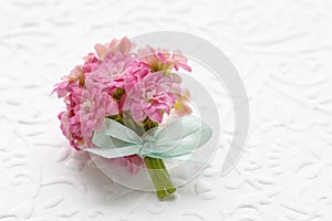 Beautiful tiny bouquet of pink kalanchoe blossfeldiana flowers and vintage sheet of paper