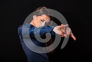 Beautiful tired business woman relaxing and doing stretching exercise on neck and shoulder blades pulling the parms in blue shirt