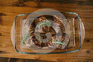 Beautiful toasted steaks in a glass plate on a wooden background, in their own juice and sprigs of rosemary.