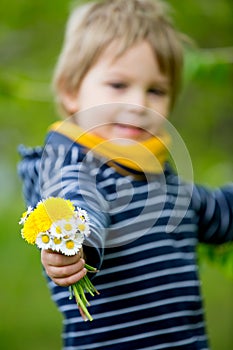 Beautiful toddler blond child, cute boy, lying in the grass