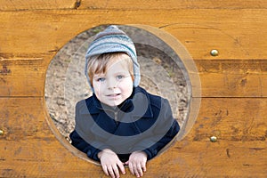 Beautiful toddler boy in blue coat on winter day