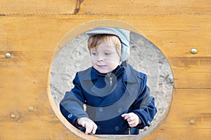 Beautiful toddler boy in blue coat on winter day