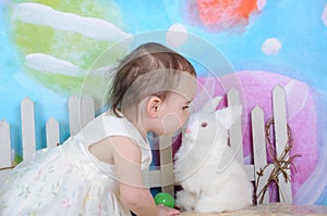 Beautiful toddler kissing bunny at easter time